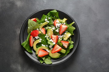 Summer Strawberry Salad with spinach, feta cheese, avocado, balsamic vinegar and olive oil in a plate. Vegan food. Healthy food concept