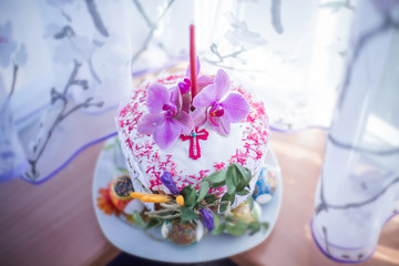 Beautiful cake at Easter decorated with fresh magnolia flowers and candle on window. consecration of cake at Easter. Homemade pasca with spring sprouts