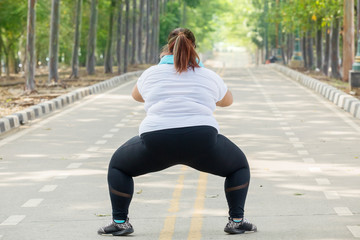 Back view of unidentified fat woman squatting