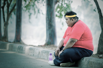 Fat Asian man resting and crossing his legs