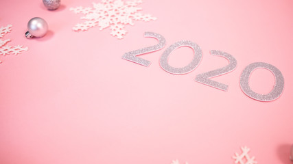 Fototapeta na wymiar 2020 Christmas and new year background banner with the beautiful decor gift for holiday in winter. On bright pink, golden and silver color theme with snow flake. top view with copy space.