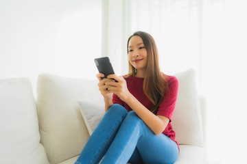 Portrait beautiful young asian women using mobile or smart phone on sofa