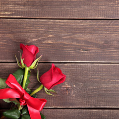 Fototapeta na wymiar Valentine background of red roses on wood. Space for copy.