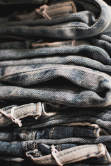 jeans stacked ina apile. Jeans in shop stacked in a neat pile for customers. Light blue, dark background