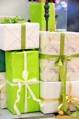 lots of packaged boxes with gifts in green, beige and gold colors. large stack of Christmas presents. christmas holidays decor.