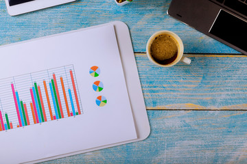 The workplace of business annual report graph diagram analisys desk with laptop and cup of coffee