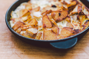 Potatoes baked with meat in the oven. Delicious dinner recipe. Potato pudding. Baked potato. Beef casserole. Potato gratin.Baked potatoes with eggs and chicken in a round bowl on a wooden table