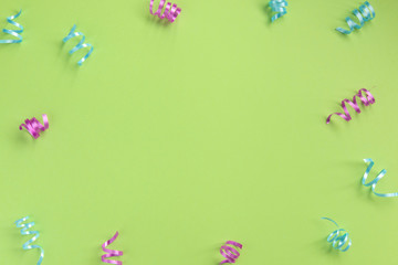 Colorful serpentine  on green  background. Celebration concept .Flat lay, top view, copy space.