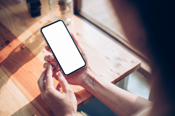 Mockup image blank white screen cell phone.woman hand holding texting using mobile on desk at home office.background empty space for advertise text.people contact marketing business,technology 