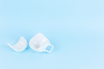 broken white cup on blue background