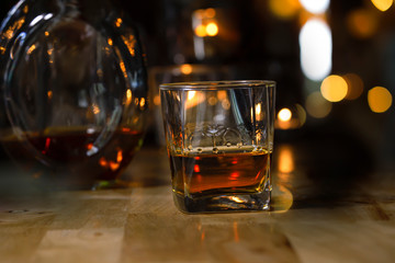 whiskey into the glass at the bar counter.