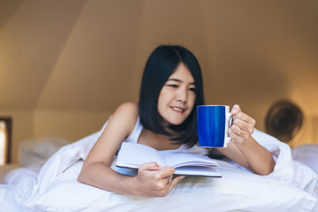 Fototapeta premium Happy asian woman holding and drinking hot coffee in the morning,Enjoys of resting time,Close up