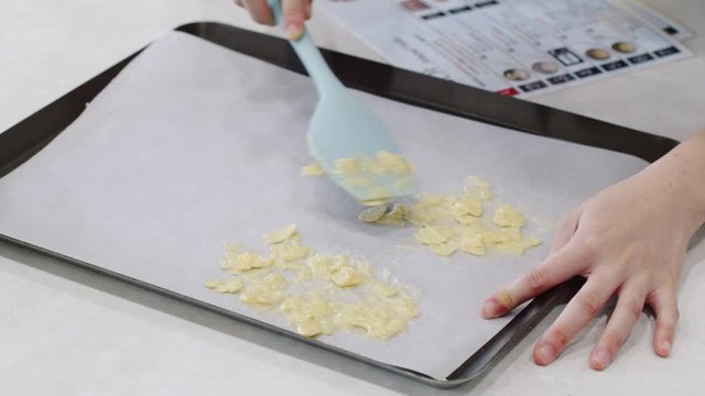 Young woman spreads out almond biscuit batter