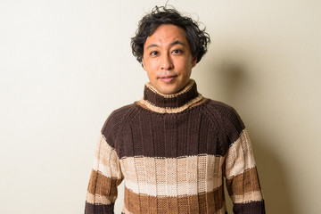 Face of Japanese man with curly hair ready for winter