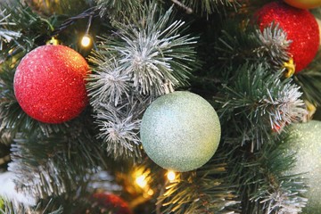 artificial spruce decorated with garlands, red and silver glass matte balls. pine tree Christmas decor