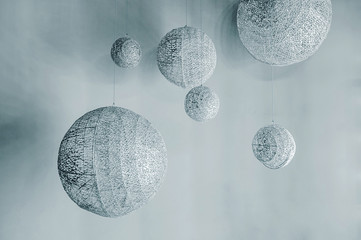 abstract space installation, silver balls of different sizes, as if planets are suspended on threads at different levels