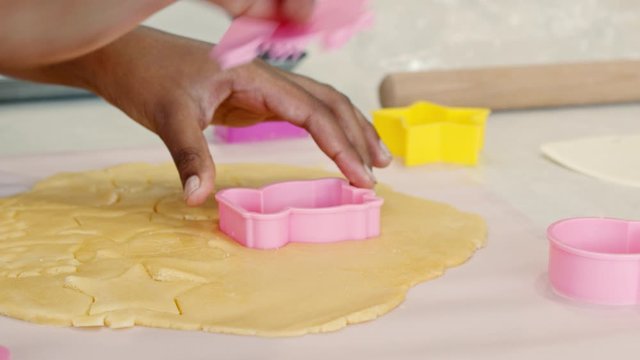 Young girl uses cookie cutter in pastry