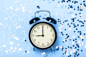 Alarm clock on a blue background with stars. The concept of preparing for sleep, an evening fairy tale, sweet dreams, etc.