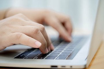 Close up hands typing on laptop keyboard.