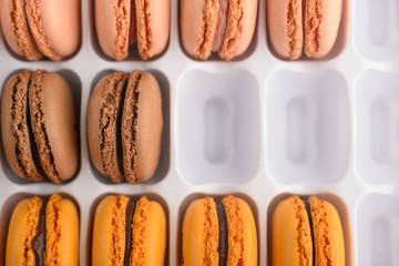 French macaroons, half-filled packaging. Photo on top, assortment. Background of sweets.