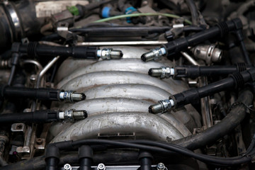 Fototapeta na wymiar Spark plugs with high voltage wires on the engine under the hood of a car during diagnosis and repair in a workshop for vehicles. Auto service industrial.