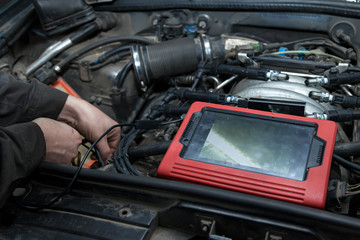Checking the condition of the surface of the engine cylinders using an endoscope camera with a wireless display showing scratches on the unit for overhaul and diagnostics. Auto service industrial.