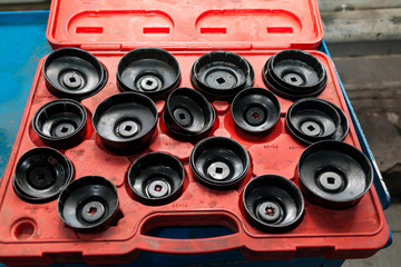 Red Box with a set of removable caps for oil filters of different sizes and diameters for the safe...