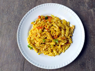 some yellow eatable food put in a white plate on stone background