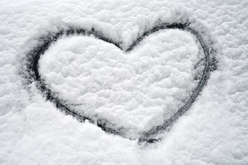 close up on drawing hearts on car windshield after snow