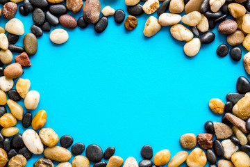 Sea stones background with blue copy space top-down frame