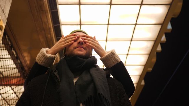 Man waiting for woman on their date as she suddenly appears fron back closing him eyes surprisely having fun together