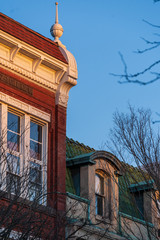 Obraz premium Renovated traditional American brick buildings with shops along a busy street in a downtown at sunset