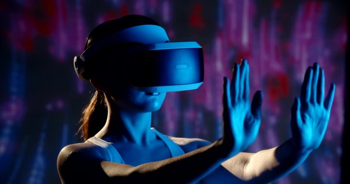 Closeup shot of authentic asian girl wearing vr helmet in world of virtual reality, interacting with her hands - cyberpunk, technology concept 4k footage