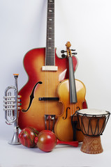 Fototapeta na wymiar Musical instruments on a light background. Guitar, violin, clarinet, trumpet, maracas, djembe.