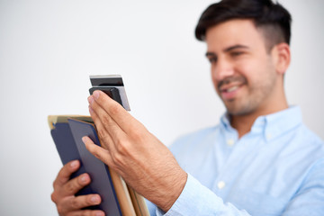 Smiling young businessman attaching credit card reader to digital tablet, selective focus