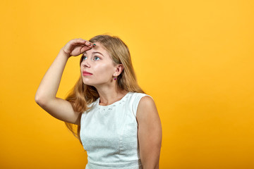 Disappointed caucasian young lady keeping hand on forehead, looking into distance over isolated...