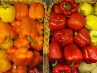 Two baskets with multi-colored yellow, orange and red peppers.