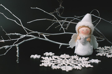 Black festive Christmas background with contrasting white objects - a natural painted white branch,...