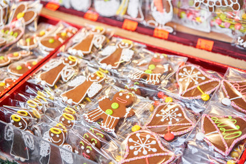 Ginger cookies of different shapes. Gingerbread man and christmas mood in blurred background. Christmas market in old town European small city.