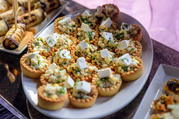 Tartlets with vegetable salad and cheese, close-up. Cold appetizers at restaurant.