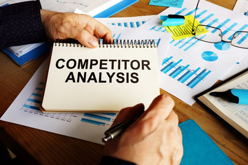 Competitor analysis report in the man hands.
