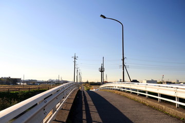 Obraz premium 冬空と農道に通じる橋風景