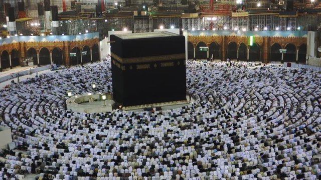 Muslim pilgrims prostrate during evening prayer facing the black stone (or Kaaba) in Mecca, Saudi Arabia.