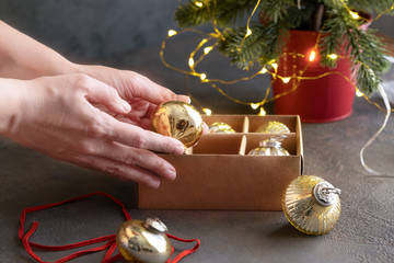 Woman taking out a Christmas ball from the craft box with different decoration for fir tree. Christmas and New Year preparation Concept .