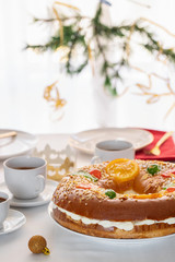 Roscon de reyes , Spanish Christmas cake on the table with traditional cup of chocolate. This desert eaten in Spain for celebrate Epiphany or Dia de Reyes Magos, Three Wise Men Day.