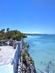 Fototapeta premium Wooden old fence on a paradise beach with a turquoise ocean against the blue sky of Cuba