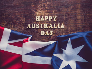 Fototapeta na wymiar Wooden unpainted letters of the alphabet on a dark background. Australia Day. Beautiful, bright card. Top view, close-up. National holiday concept