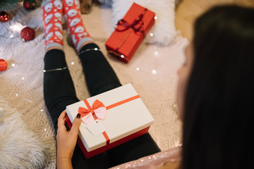Girl sitting on floor with gift box on her legs