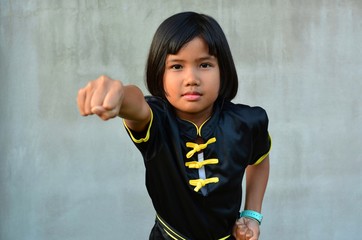 Cute sport girl practicing wushu (Kung fu , gongfu) , Chinese martial arts concept. 