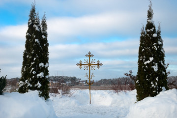 Obraz premium Obedient orthodox cross between trees on a winter day